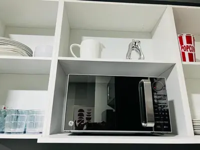 a white cabinet with a microwave in a kitchen at Elegante y acogedor apartamento en el corazón de San Salvador in San Salvador