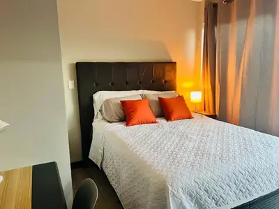 a bedroom with a bed with two orange pillows at Elegante y acogedor apartamento en el corazón de San Salvador in San Salvador