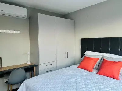 a bedroom with a large bed with two red pillows at Elegante y acogedor apartamento en el corazón de San Salvador in San Salvador