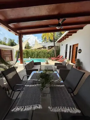 a patio with a table and chairs and a pool at 1 Family Pool Villa BBQ PARKING EL SUNZAL Surf City Area in El Sunzal