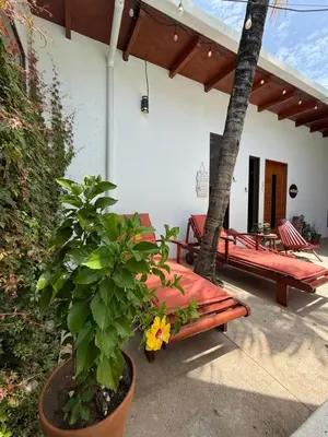 a porch of a house with a bench and a tree at 1 Family Pool Villa BBQ PARKING EL SUNZAL Surf City Area in El Sunzal