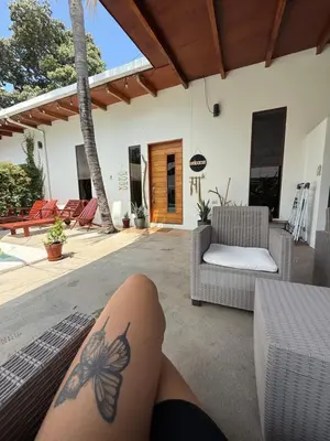 a woman with a butterfly tattoo on her leg on a patio at 3 Family Villa Private Pool Parking BBQ El Sunzal El Tunco El Zonte SURFCITY in Tamanique