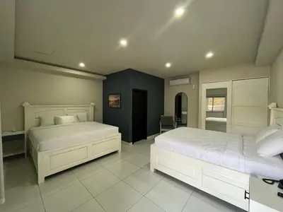 a bedroom with two beds and a blue wall at Hotel Mar Azul in Playa Negra