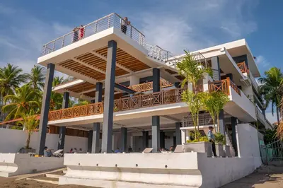 a building with a balcony on the beach at Hotel Mar Azul in Playa Negra