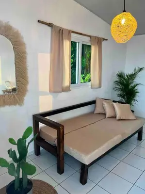 a couch sitting in a room with a window at Surf House Mizata in Santa María Mizata