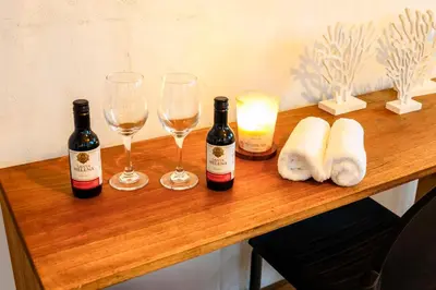 a wooden table with wine bottles and glasses on it at Surf House Mizata in Santa María Mizata