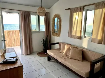 a living room with a couch and some windows at Surf House Mizata in Santa María Mizata