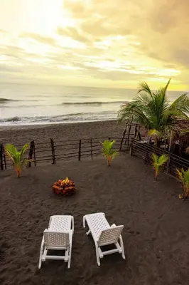 two chairs and a fire pit on a beach at Surf House Mizata in Santa María Mizata