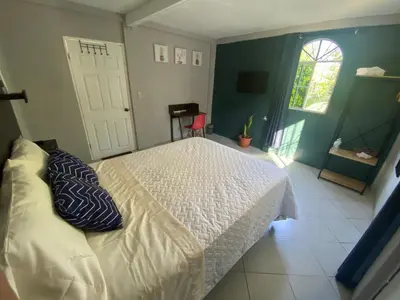 a bedroom with a white bed with a pillow on it at Habitación cerca del aeropuerto #1 in Tilapa