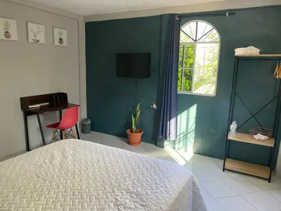 a bedroom with a bed and a window and a chair at Habitación cerca del aeropuerto #1 in Tilapa