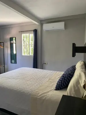 a bedroom with a white bed with a window at Habitación cerca del aeropuerto #1 in Tilapa