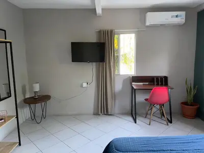 a bedroom with a bed and a desk and a red chair at Habitación cerca del aeropuerto #2 in La Paz