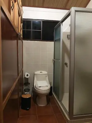 a bathroom with a toilet and a walk in shower at Hostal Santa Clara B&B in Apaneca