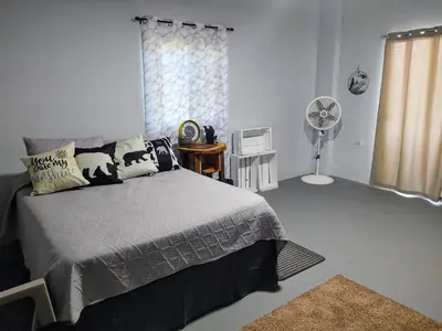 a bedroom with a bed and a fan at Rancho Del Oso Tuerto in Marcelino