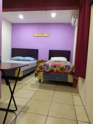 two beds in a room with a purple wall at Comfort Home Escalón in San Salvador