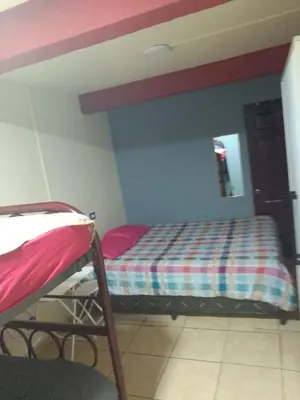 a bedroom with a bed with a striped bedspread at Comfort Home Escalón in San Salvador