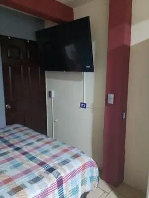 a bedroom with a bed with a flat screen tv on the wall at Comfort Home Escalón in San Salvador
