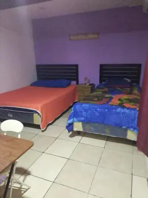 two beds in a bedroom with purple and purple walls at Comfort Home Escalón in San Salvador