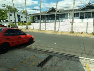 a red car parked on the side of a street at Comfort Home Escalón in San Salvador
