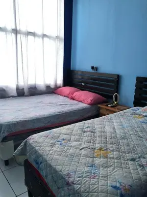 a bedroom with two beds and a blue wall at Comfort Home Escalón in San Salvador