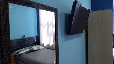 a mirror in a room with a bed and a window at Comfort Home Escalón in San Salvador