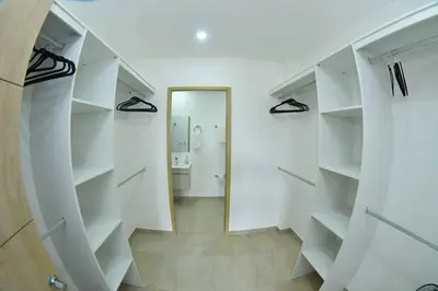 a walk in closet with white shelves and a mirror at Margo 306- Luxe, Elegant & Cozy Condo- City Center in San Salvador