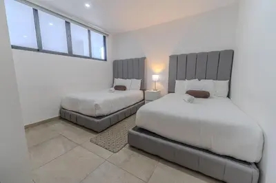 a bedroom with two beds and a window at Margo 306- Luxe, Elegant & Cozy Condo- City Center in San Salvador