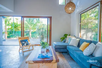 a living room with a blue couch and a table at SantiChanti Walk to Sunzal Beach in Tamanique