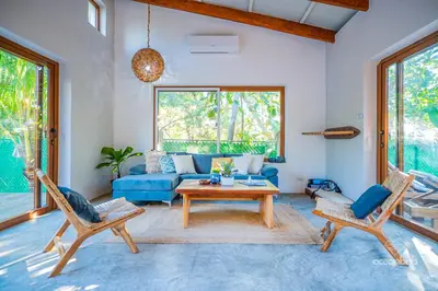 a living room with a blue couch and a table at SantiChanti Walk to Sunzal Beach in Tamanique