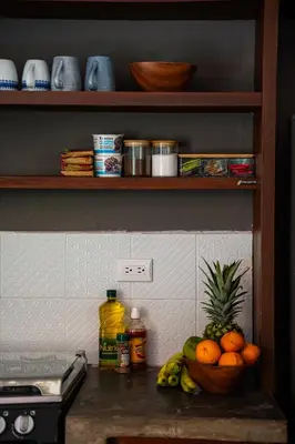 a counter with a bowl of oranges and a bowl of fruit at SantiChanti Walk to Sunzal Beach in Tamanique