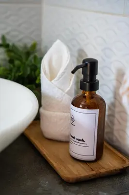 a bottle of essential oil on a cutting board with towels at SantiChanti Walk to Sunzal Beach in Tamanique