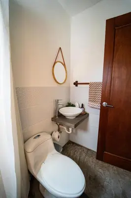 a bathroom with a toilet and a sink at SantiChanti Walk to Sunzal Beach in Tamanique