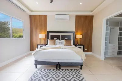 a bedroom with a large bed and a window at Family Friendly Guanaco House El Salvador AC, Wi-Fi, Hot Water, & Enjoy Your Stay in Santa Ana