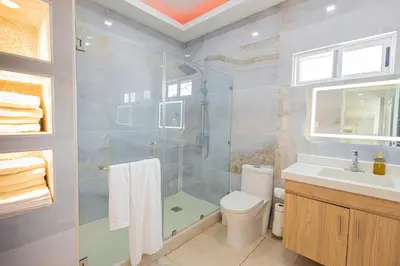 a bathroom with a shower and a toilet and a sink at Family Friendly Guanaco House El Salvador AC, Wi-Fi, Hot Water, & Enjoy Your Stay in Santa Ana