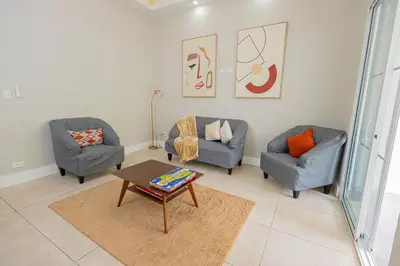a living room with two chairs and a coffee table at Family Friendly Guanaco House El Salvador AC, Wi-Fi, Hot Water, & Enjoy Your Stay in Santa Ana