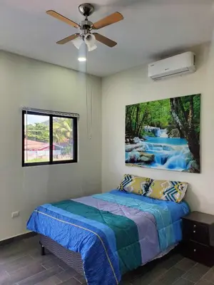 a bedroom with a bed with a painting on the wall at Casa Zelaya en Isla San Blas, La libertad salvador in La Libertad