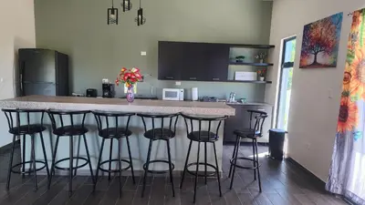 a kitchen with a counter and bar stools at Casa Zelaya en Isla San Blas, La libertad salvador in La Libertad