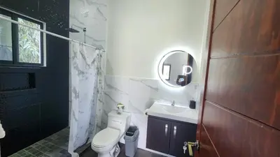 a bathroom with a toilet and a sink and a mirror at Casa Zelaya en Isla San Blas, La libertad salvador in La Libertad
