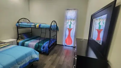 a room with two bunk beds and two windows at Casa Zelaya en Isla San Blas, La libertad salvador in La Libertad