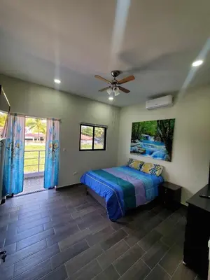 a bedroom with a bed and a ceiling fan at Casa Zelaya en Isla San Blas, La libertad salvador in La Libertad