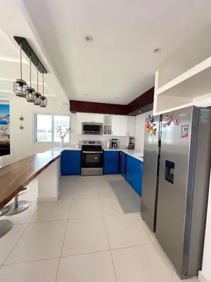 a kitchen with blue cabinets and a stainless steel refrigerator at Mariposa Reina B in El Jagüey