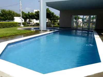 a large blue swimming pool in front of a building at Disfruta y siéntete como en casa in San Miguel