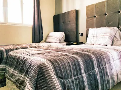 a bedroom with two beds and a window and a bedskirts at Disfruta y siéntete como en casa in San Miguel