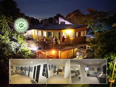 a house with people standing on a deck at night at Apto para turismo. Moderno cómodo y panorámico. in San Salvador