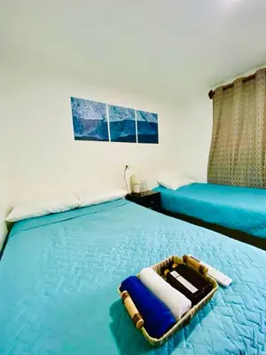 a bedroom with two beds with towels on them at Mayara Hostal in El Zonte