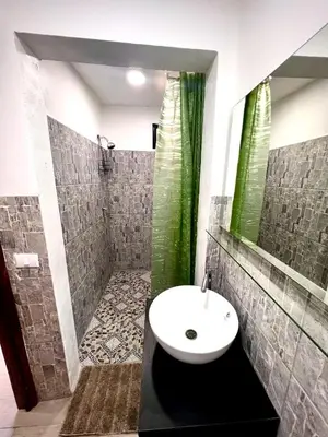 a bathroom with a sink and a shower at Mayara Hostal in El Zonte