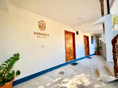 a facade of a villa with a sign on the wall at Mayara Hostal in El Zonte