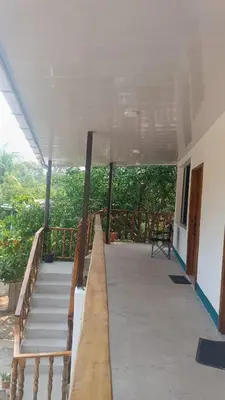 a balcony of a house with stairs and a view at Mayara Hostal in El Zonte