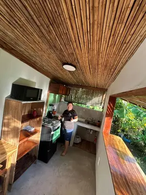 a woman standing in the kitchen of a tiny house at Mayara Hostal in El Zonte