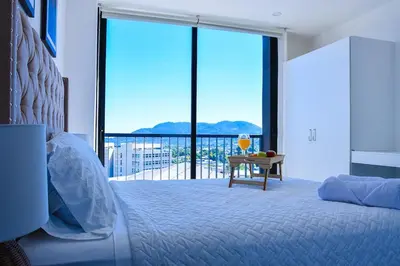 a bedroom with a bed and a balcony with a view at Modern Apartment in Downtown. A/C+ Wifi! in San Salvador